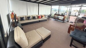 Un salon moderne comprenant un canapé, une table basse et un coin repas avec des chaises.