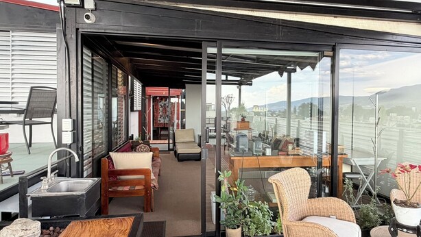 Une terrasse extérieure moderne, aménagée avec une table à manger, des chaises et un évier.