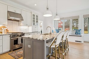 A kitchen with a central island, stainless steel appliances, and a view of the outside. - 3 Mins to York Beach | Large Deck | Water View (York)