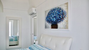 Ein Schlafzimmer mit einem Bett, einem Spiegel und einem Wandbild.