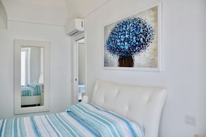 Ein Schlafzimmer mit einem Bett, einem Spiegel und einem Wandbild.
