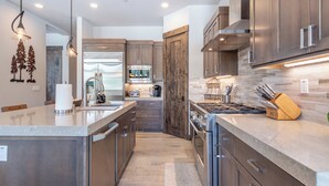 A modern kitchen with stainless steel appliances, wooden cabinets, and a central island. - Fairway Estate: Hot Tub, Fire Pit & Dog Friendly (Truckee)