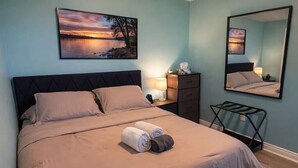 A bedroom with a bed, a nightstand, a dresser, a mirror, and a wall-mounted picture. - Hot Tub Retreat Near Downtown & Casino | Sleeps 8 | Cozy Luxury Stay for family✨ (Windsor)