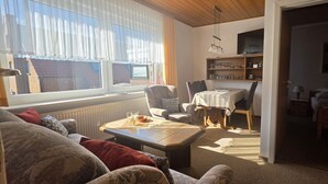Una sala de estar acogedora con un sofá, una mesa de centro y un comedor con mesa y sillas.