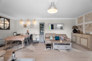 Ein modernes Wohnzimmer mit Essbereich, einer Couch, einem Couchtisch und einem Schrank.