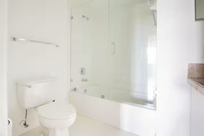 A bathroom with a toilet, a glass shower enclosure, and a sink. - Amazing 2-bedroom apartment with AC in vibrant Miami (Miami)