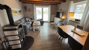 Una sala de estar moderna con chimenea, sofá, mesa de comedor y televisor.
