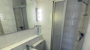A bathroom with a sink, toilet, bidet, and shower. - Pelikan vacation apartment (Hooksiel)