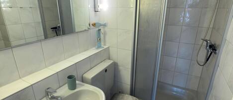 Une salle de bain équipée d’un lavabo, de toilettes, d’un bidet et d’une douche.