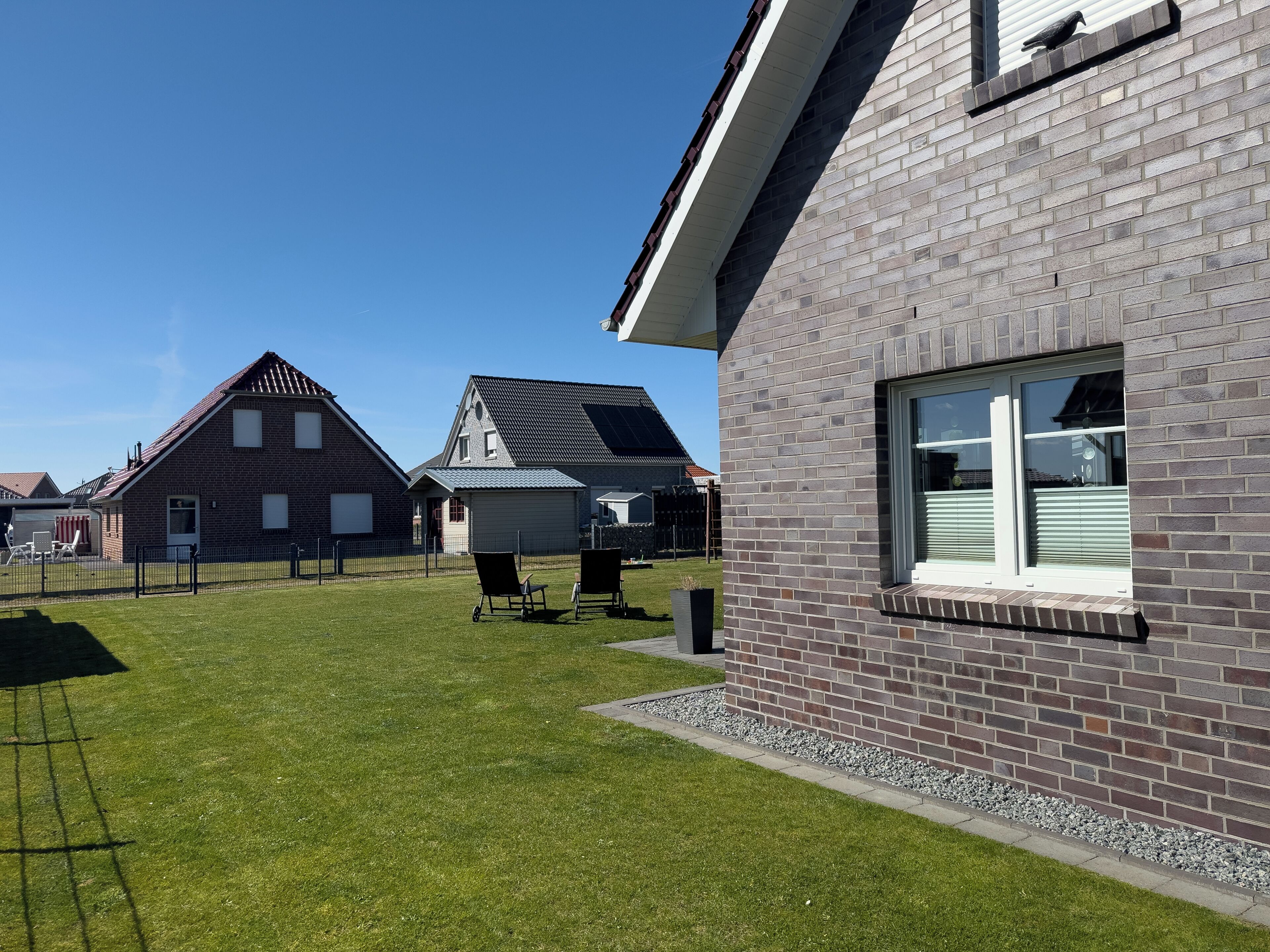Un quartier résidentiel avec des maisons, une pelouse bien entretenue et un ciel dégagé.