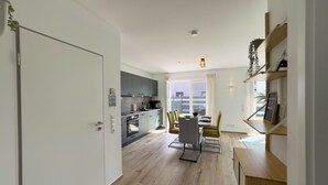 A modern apartment with a kitchen, dining area, and a living space. - The "Genießerei" vacation apartment on the Wangermeer invites you to relax with its terrace, dog-friendly atmosphere and wallbox at the parking space. (Wangerland)