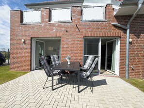 Outdoor dining - The "Genießerei" vacation apartment on the Wangermeer invites you to relax with its terrace, dog-friendly atmosphere and wallbox at the parking space. (Wangerland)