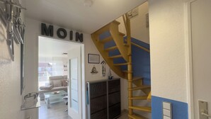 A staircase leading to a landing with a sign reading 'MOIN' above it. - Modern vacation apartment in Hooksiel with sunny balcony, two bedrooms, attic reading corner and quiet, central location near the North Sea. (Hooksiel)
