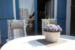 A round table with a potted plant and a butterfly decoration. - Cozy semi-detached house in Hooksiel with fireplace, garden, three bedrooms, two bathrooms and dog-friendly furnishings - ideal for a family vacation by the North Sea. (Hooksiel)