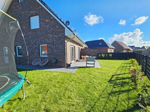 Outdoor dining - Family-friendly vacation home directly on the Wangermeer with space for 6 people, modern furnishings, terrace, underfloor heating, play corner and trampoline - ideal for a relaxing family vacation. (Wangerland)