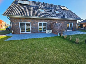 Property grounds - Family-friendly vacation home directly on the Wangermeer with space for 6 people, modern furnishings, terrace, underfloor heating, play corner and trampoline - ideal for a relaxing family vacation. (Wangerland)