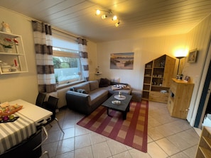 Una sala de estar con sofá, mesa de centro y un mueble de madera.