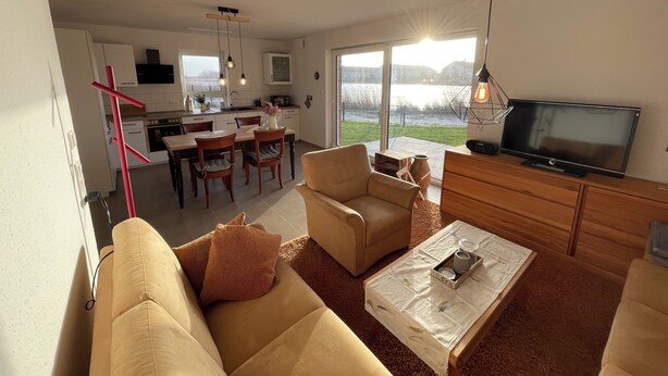 Een moderne woonkamer met een bank, salontafel en televisie.