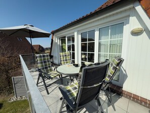 Outdoor dining - Cozy vacation apartment with a large southwest-facing balcony, fireplace and comfortable furnishings - the Klabautermann in Hooksiel invites you to relax by the North Sea. (Hooksiel)