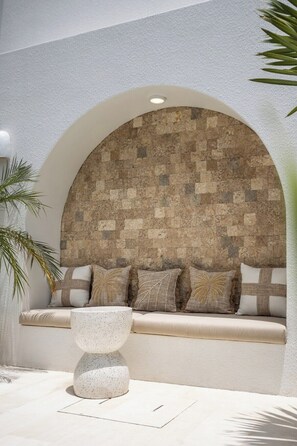 Een modern interieur met een wand met een stenen patroon, een comfortabele bank en een tafel met spikkels.