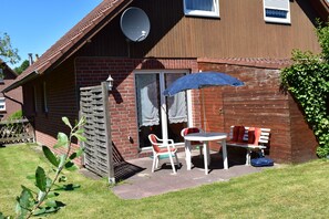 Outdoor dining - The Nordlys vacation home on the North Sea offers modern comfort with a wood-burning stove, south-west-facing terrace and fenced garden - perfect for families and couples. (Hooksiel)