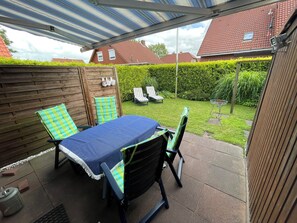 Outdoor dining - The charming Tillmann vacation home offers modern furnishings, a cozy wooden ambience and a sunny southwest-facing terrace - just a few minutes' walk from the dyke. (Hooksiel)
