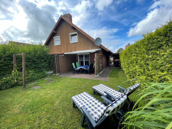 Outdoor dining - The charming Tillmann vacation home offers modern furnishings, a cozy wooden ambience and a sunny southwest-facing terrace - just a few minutes' walk from the dyke. (Hooksiel)