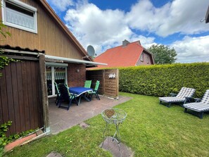 Outdoor dining - The charming Tillmann vacation home offers modern furnishings, a cozy wooden ambience and a sunny southwest-facing terrace - just a few minutes' walk from the dyke. (Hooksiel)