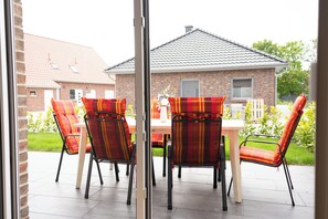 Outdoor dining - The modern vacation home Wanger Meerblick offers high-quality living comfort, three bedrooms, a fenced garden and a wonderful view of the Wangermeer - perfect for families and dog owners. (Wangerland)