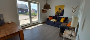A living room with a sofa, a table, a lamp, and a painting.