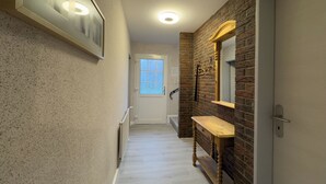 A hallway with a wooden bench, a mirror, and a door. - The Windfang 2 vacation home in Hooksiel offers modern comfort, a quiet location and a sunny terrace - perfect for relaxing days by the North Sea. (Hooksiel)