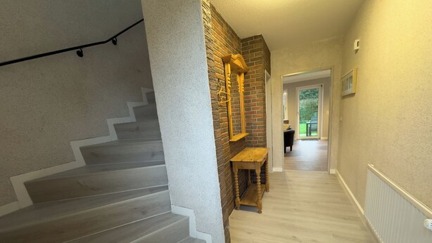 A staircase with wooden steps and a brick wall. - The Windfang 2 vacation home in Hooksiel offers modern comfort, a quiet location and a sunny terrace - perfect for relaxing days by the North Sea. (Hooksiel)