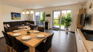 Un comedor moderno con una mesa de madera dispuesta para cuatro personas, rodeada de sillas negras.