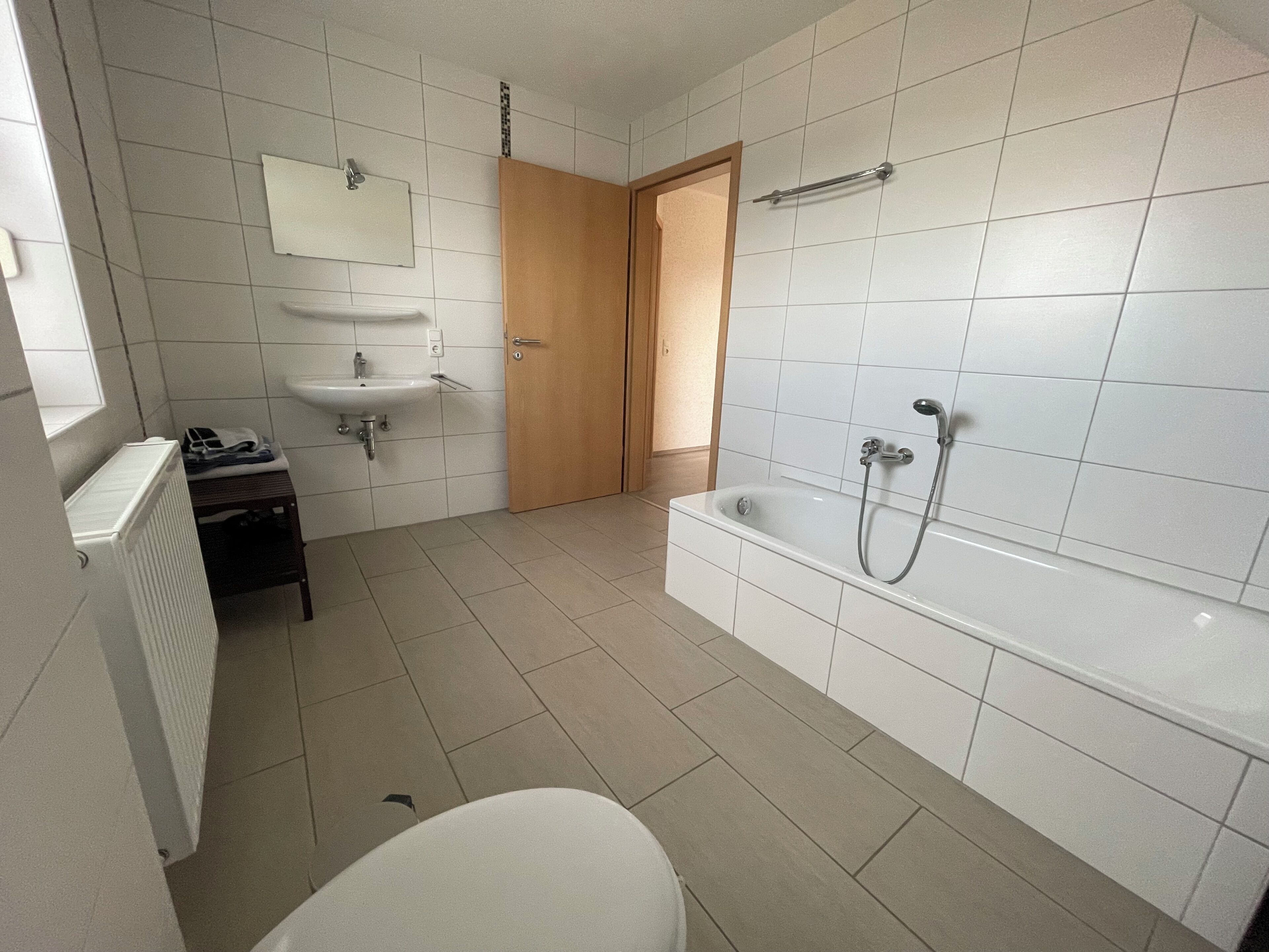 Et badeværelse med badekar, vask og toilet.