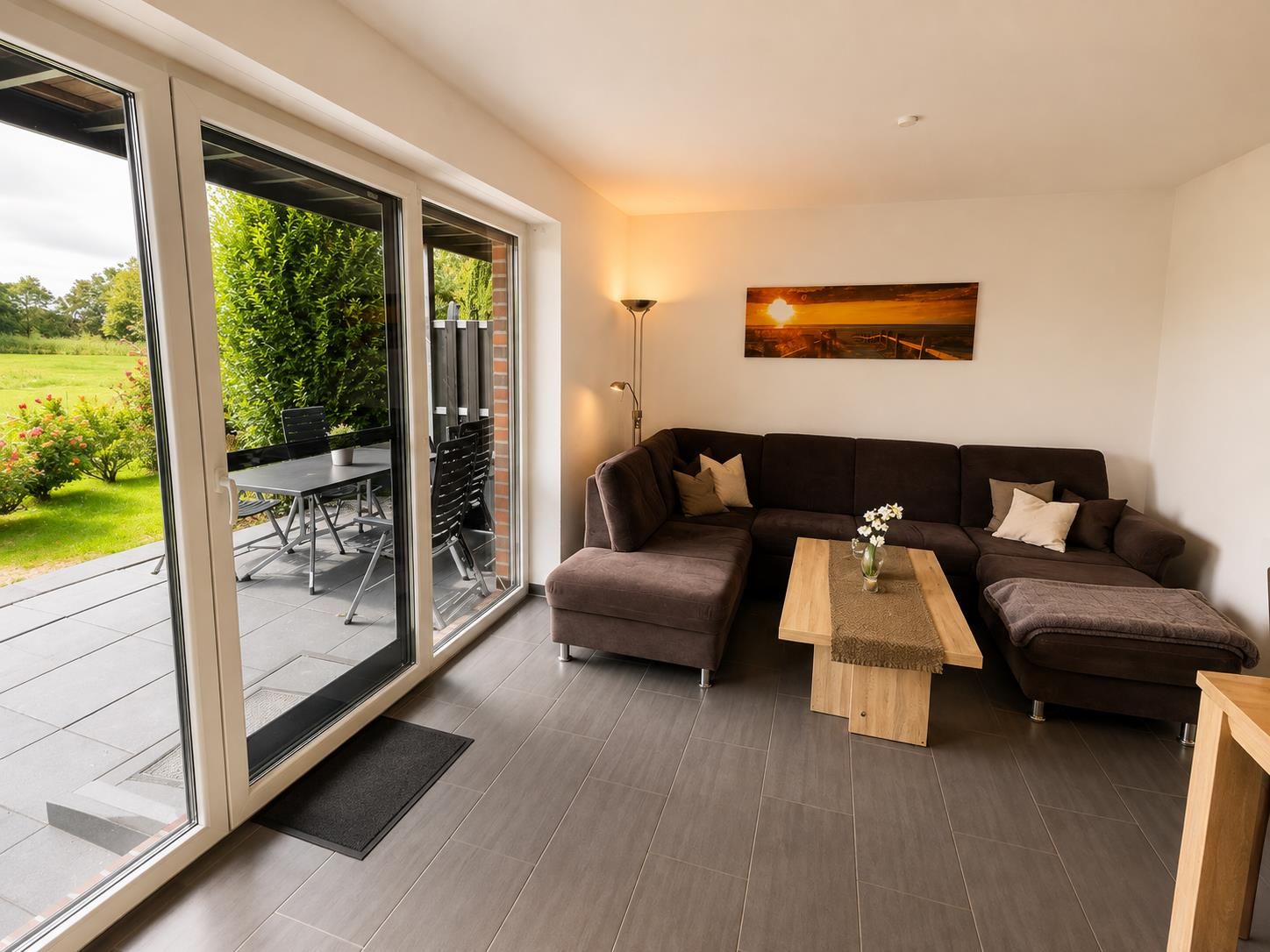 Ein modernes Wohnzimmer mit einer Eckcouch, einem Couchtisch und einem Essbereich mit Stühlen und einem Tisch.
