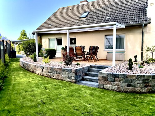 Vacation home "Rosenwind" in Wangerland: 5 bedrooms for up to 9 people, 2 bathrooms, wood-burning stoves, large kitchen and garden with conservatory - ideal for a North Sea vacation.