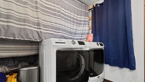 Une buanderie équipée de deux machines à laver à chargement frontal et d’un sèche-linge.
