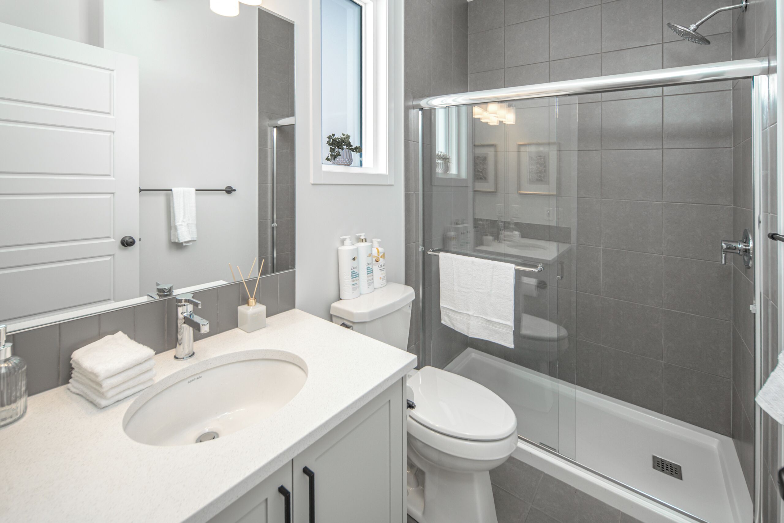 Ein modernes Badezimmer mit Waschbecken, Toilette und einer Duschkabine.