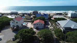 Une zone résidentielle côtière avec des maisons, une plage et l’océan.