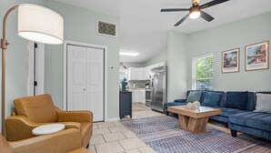 A living room with a sofa, a coffee table, a lamp, and a ceiling fan. - Portside Retreat: Quiet wooded stay, where everything just short drive away (Wilmington)
