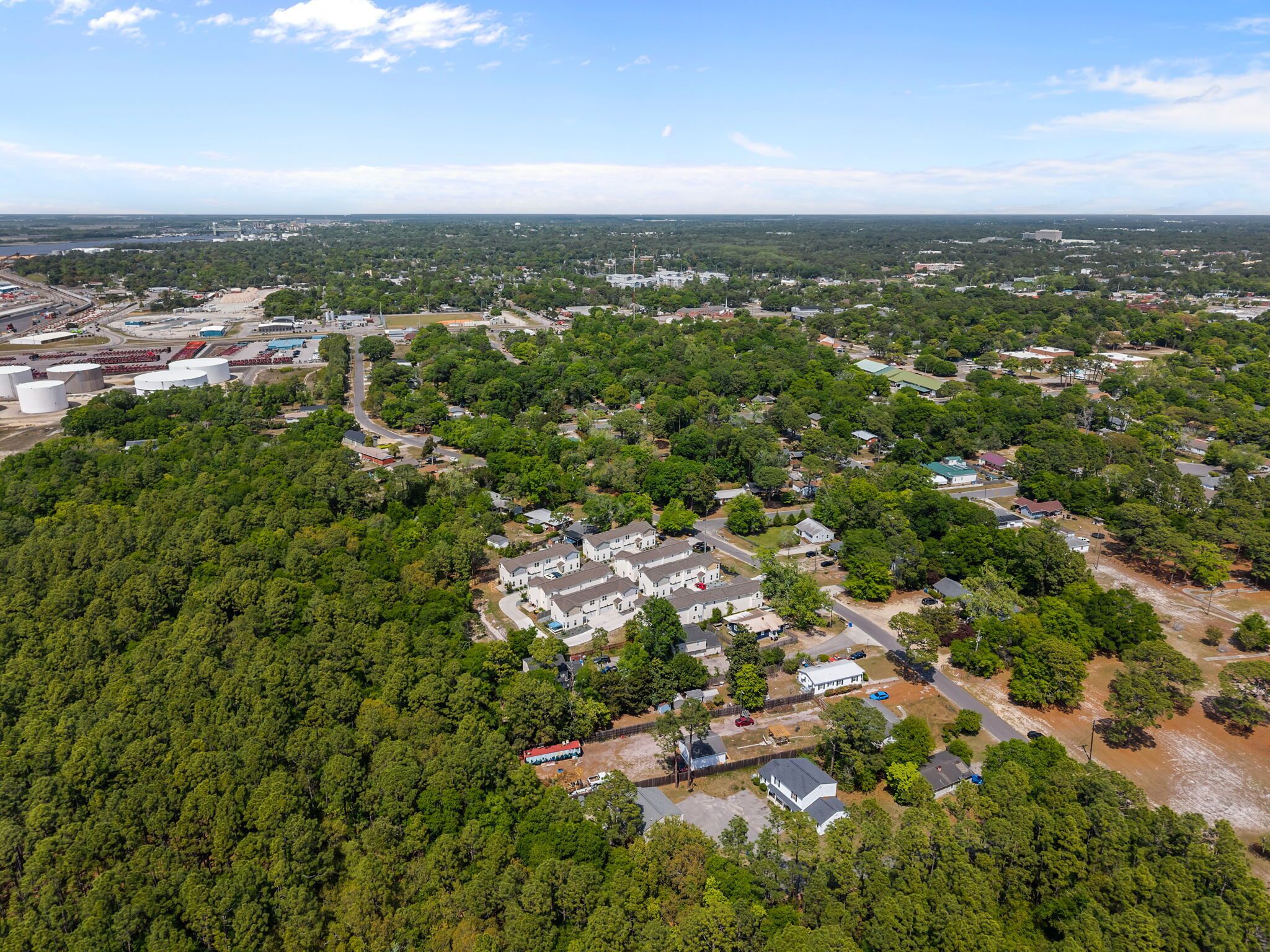 An aerial view of a residential area with houses, roads, and industrial buildings.