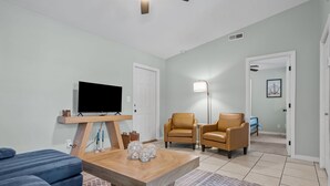 A living room with a TV, two leather chairs, a coffee table, and a patterned rug. - Portside Retreat: Quiet wooded stay, where everything just short drive away (Wilmington)