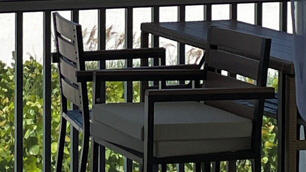 Een balkon met uitzicht op de oceaan en het strand.