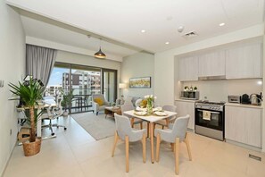 Eine moderne Wohnung mit Essbereich, Küche und einem Balkon mit Blick.