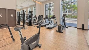 A gym with treadmills, elliptical machines, and weight machines. - Work & Chill 1BR w/ Office + PS5 Dubai Creek (Dubai)