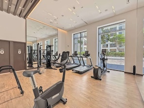 Ein Fitnessstudio mit Laufbändern, Crosstrainern und Krafttrainingsgeräten.
