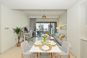 Eine moderne Wohnung mit Essbereich, einer Couch, einem Topfpflanze und Blick auf Gebäude.