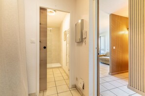 A hallway with a shower, a phone, and a wooden partition. - Little Pignada - Proche Plage (Seignosse)