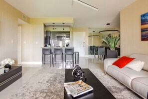 A modern living room with a sofa, coffee table, and a dining area with chairs and a table. - Cozy 1-bedroom apartment in amazing Miami with AC (Miami)