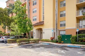 A multi-story residential building with a parking lot, a green gate, and a wheelchair-accessible entrance. - Cozy 1-bedroom apartment in amazing Miami with AC (Miami)